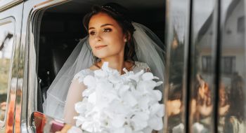 a bride looks out of the window of her wedding day transportation