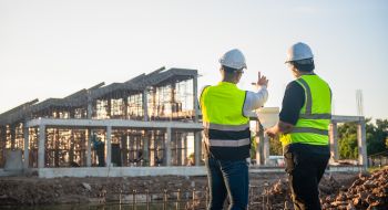 construction workers discussing project plans at a busy worksite